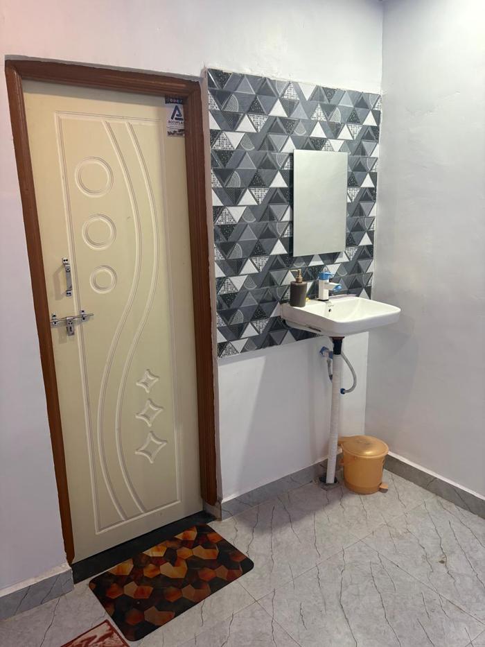 Washbasin and mirror beside the bathroom door at the Nandai Gate stay.