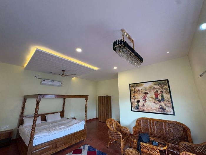 Room lighting, four-poster bed and wicker seating at the Bhavankhori Gate stay.