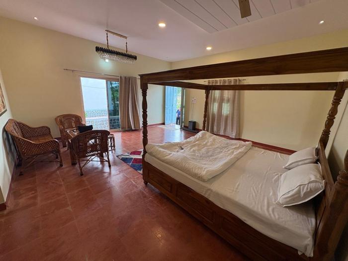 View across the four-poster bed towards the room entrance at the Bhavankhori Gate stay.