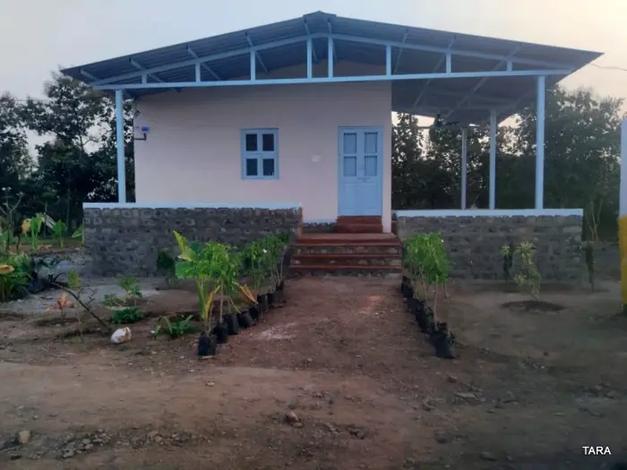 Cottage front with a blue door and plant-lined entrance at the Bhavankhori Gate stay.